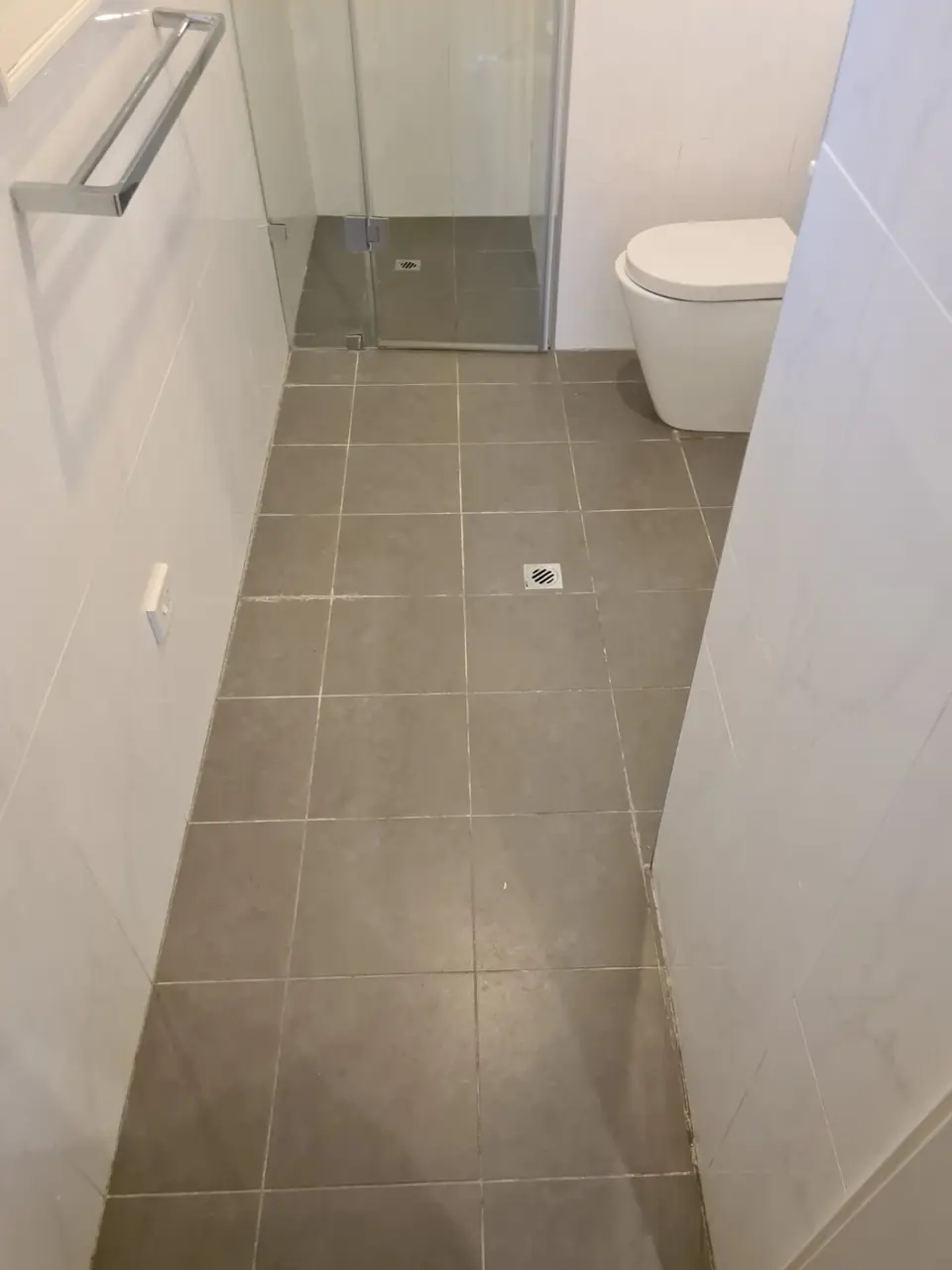 Before: grey bathroom floor with dull grout.