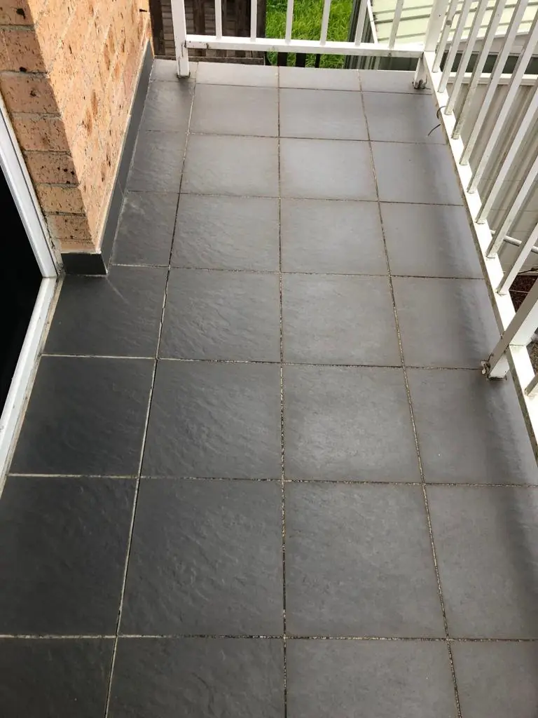 Before: slate-look balcony with discoloured grout.