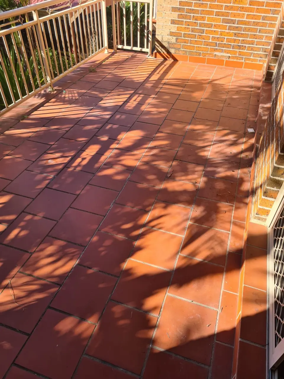 Before: terracotta balcony with weathered grout.