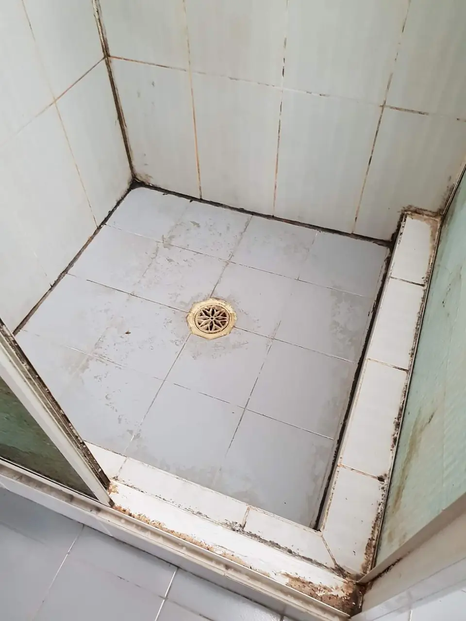Before: white shower base with a worn hob and stained corners.
